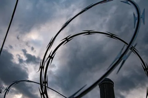 Low Angle Barbed Wire Against Clouds Stock Photos