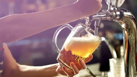 Low angle of Bartender pouring foamy beer filling glass cup in slow motion .. Stock Footage 265766601