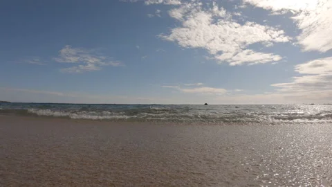 Low angle beach parallel to shoreline with gentle waves Stock Footage 132936219