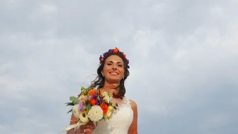 Low angle of a beautiful bride running against a blue sky, slow motion Stock Footage 100270644