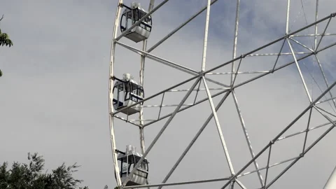 Low Angle Of The Big Ferris Wheel With Closed Cabins On Blue Sky With Cloud Back Stock Footage 203801182