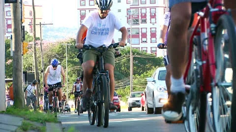 Low angle of bikers going up on a steep street (PoAbikes36) Stock Footage 23739199