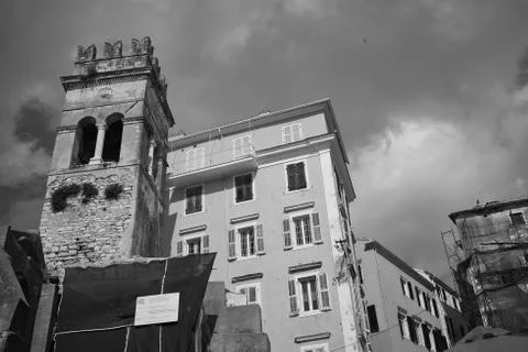 A low angle black and white shot of high buildings under the crazy cloudy sky Stock Photos