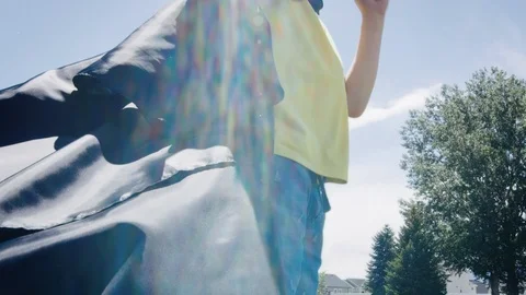 Low angle of black cape billowing as boy pretends to be superhero and runs off Stock-Footage 127547679