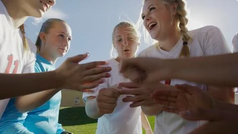 Low angle blurred view of soccer team players cheering in huddle before game 스톡 사진