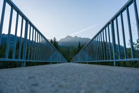 Low Angle Bridge Leading to Mountain Landscape With Railings and Pine Fores.. Foto stock