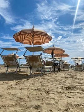 Low-angle, bright sun-drenched view of a sandy beach in Cesenatico, featuri.. Stock Photos