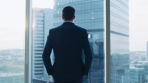 Low Angle Businessman Looking out of Office Window on Big City Stock Footage