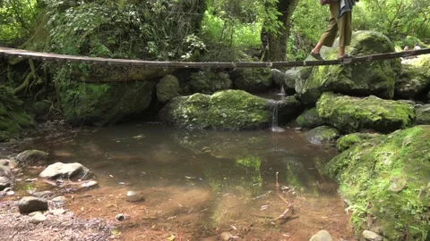 Low angle camera, legs walking on a suspension bridge. Hiker woman Stock Footage 159841232