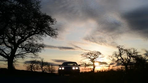 Low angle car driving on country road at sunrise york united kingdom Stock Footage 143459010