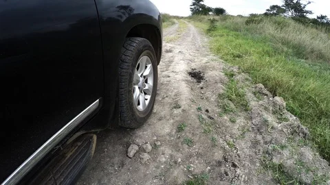 Low angle car tire driving on dirt path in Africa Video stock 106963298