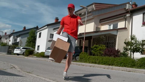 LOW ANGLE: Careless young courier kicking customers' orders at their doorsteps. Stock Footage 140037492