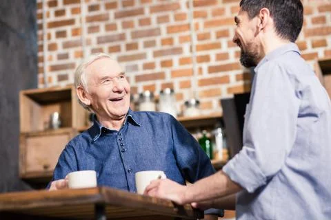 Low angle of cheerful aged mna talking with his son Stock Photos
