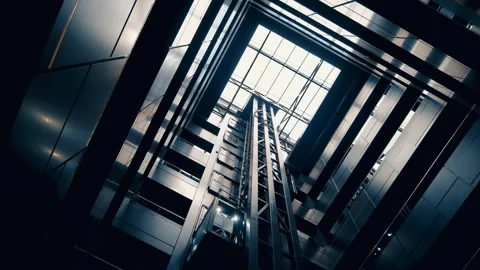 A low-angle cinematic footage of modern glass elevators moving up and down .. Stock Footage 339203772