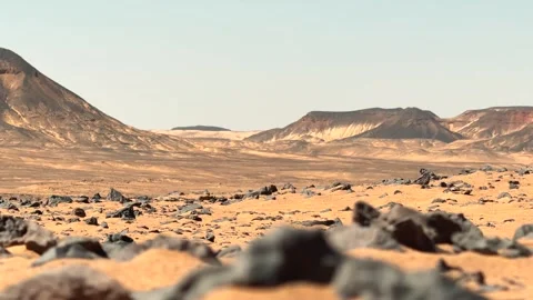 Low angle cinematic panorama of volcanic hill rising above desert plain with Vidéo 340867777
