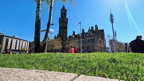 Low-angle cinematic view of Bradford City Hall clock tower from grass Stock Footage 334995555