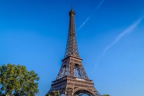 Low-angle close-up of the Eiffel Tower against a vivid deep. Stock Photos