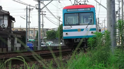 Low Angle Close Up Electric Commuter Train Travels Past Grass In Kyoto 4K Stock Footage 44927155