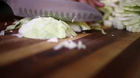 Low angle close-up food prep: Chopping cabbage on wood cutting board Video stock 328975530