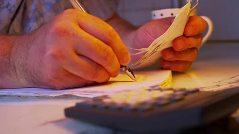 Low angle close-up of hands copying receipt data into a financial noteboo Stock Footage 336978081
