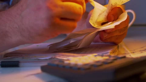 Low angle close-up of hands flipping through paper receipts Stock Footage 336987125