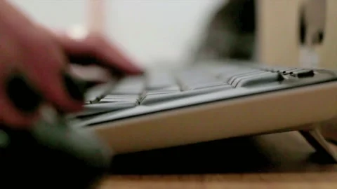 Low-Angle Close-up of Hands Typing Fast on a Dark Desktop Keyboard Stock Footage 320521601