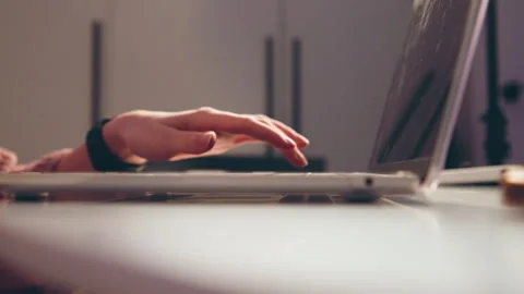 Low-angle close-up of hands typing on laptop keyboard, fingers poised for input Stock Footage 343543601