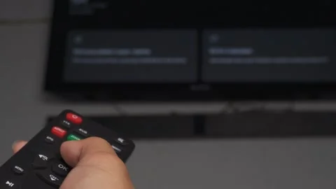 Low angle close up of hands using remote with tv in background Stock Footage 276636098