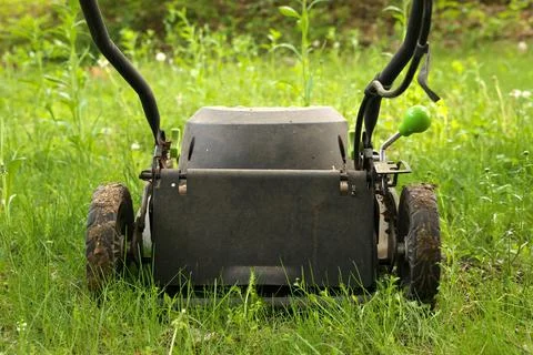Low Angle Close up lawnmower ready to be cutting long grass or illustrating Stock Photos