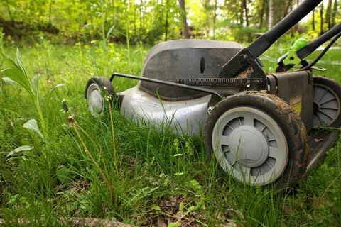 Low Angle Close up lawnmower ready to be cutting long grass or illustrating Stock Photos