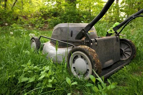 Low Angle Close up lawnmower ready to be cutting long grass or illustrating Stock Photos