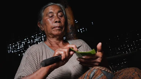 Low angle close up of local Balinese woman preparing banana leaf rolls, Bali Stock-Footage 140255622