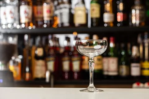 Low angle close up perspective of crystal clean empty coupe glass on bar coun Stock Photos