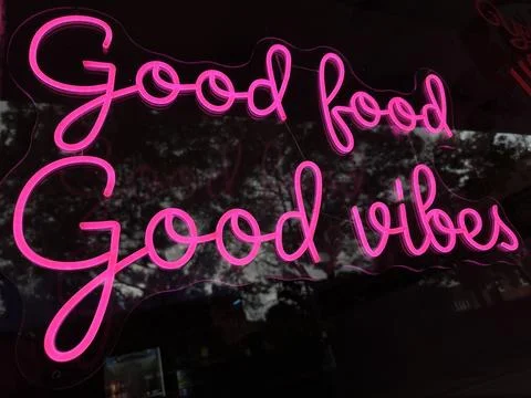 Low angle close up of pink good food good vibes sign Stock Photos