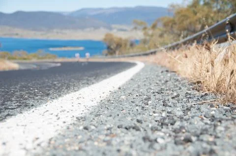 Low angle close up of a road with two out of focus riders Stock Photos