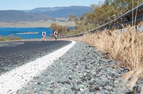 Low angle close up of a road with two out of focus riders Stock Photos