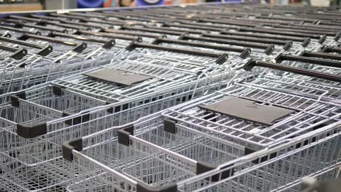 Low-angle close-up shot of a row of pristine, empty shopping carts available for Stock Footage 315175479