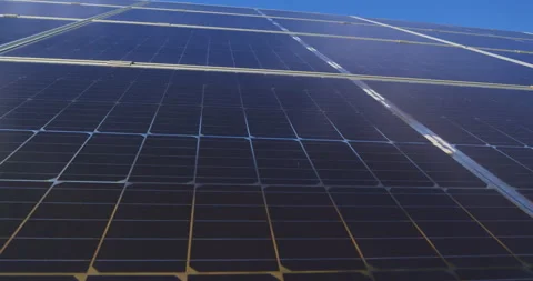 Low-angle Close solar panels generating clean renewable energy under blue sky Stock Footage 302221311