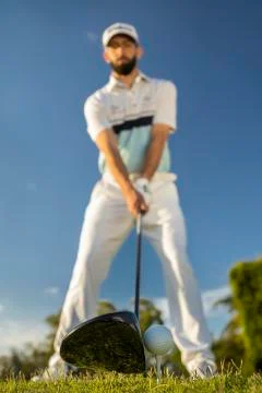 Low angle close up view of golfer preparing for tee off blue sky background Stock Photos