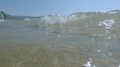 Low angle close up of waves rolling over the camera on the city beach with Stock Footage 341544108