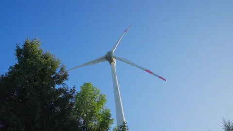 Low Angle Close-Up of a Wind Turbine Rotating Against a Clear Blue Sky 動画素材 338350005