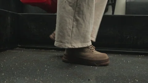 Low-angle close-up of worn work boots stepping across speckled vehicle floor Stock Footage 343523601