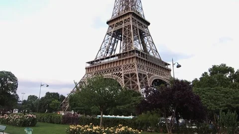 Low angle closeup of the famous Eiffel Tower in Paris, France surrounded by lush Stock Footage 158604787