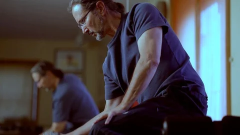 Low angle closeup of mature man curling weights with his out of focus Stock Footage 99646140