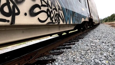 Low Angle Closeup of Passing Train with Gang Graffiti Stock Footage 81415610