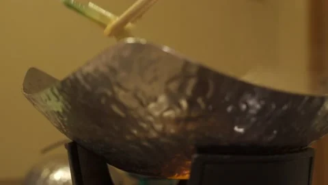 Low angle closeup of person grabbing vegetables from shabushabu hot pot Stock Footage 157666516