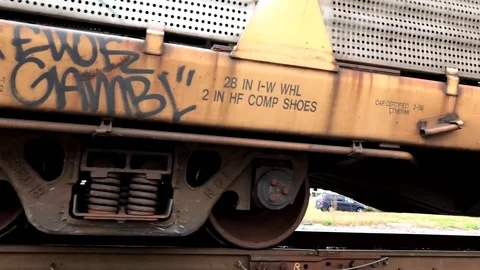 Low Angle Closeup of Train Wheels Passing on Track with Traffic in Background Stock Footage 81415480