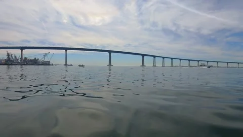 Low angle of Coronado Bridge spanning San Diego Bay under partly cloudy sky. Stock Footage 331489111