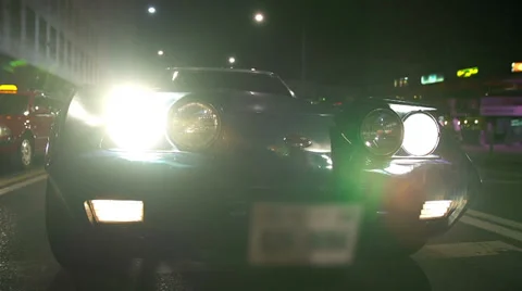 Low angle Corvette C3 shot at night drive through city Video stock 33003879