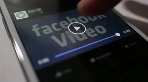 Low angle CU smartphone plays 'Facebook Video', then dolly out Stock Footage 58654815